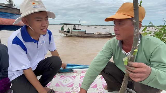 Thạch Hoàng Anh (bìa trái) hướng dẫn người dân kỹ thuật sử dụng “áo giáp hạt giống”