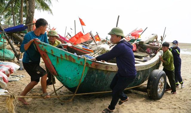 Ngư dân Sầm Sơn kéo thuyền bè lên bờ tránh bão số 5- Ảnh 1.