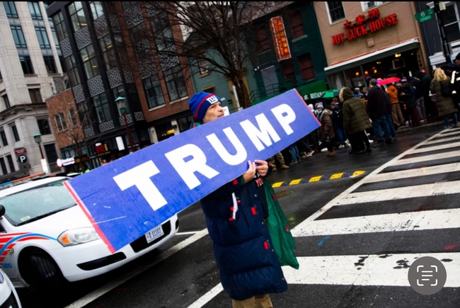 Một người đàn ông cầm tấm bảng ghi chữ Trump ở Washington hôm 19-1. Ảnh: NBC News