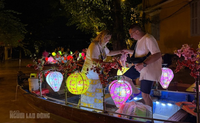 Foreign tourists excited to explore Hoi An ancient town by boat in the flood season - Ảnh 2.