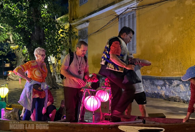 Foreign tourists excited to explore Hoi An ancient town by boat in the flood season - Ảnh 4.