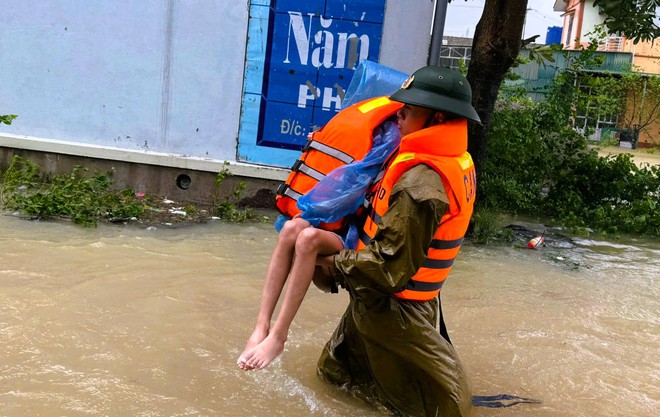 Cảnh sát căng dây, ngâm mình trong nước lũ giải cứu 22 người mắc kẹt trong bão số 10- Ảnh 5.