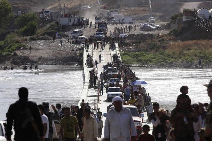 Nhiều người Yazidi quay trở lại Iraq sau khi trốn thoát khỏi thị trấn Sinjar hôm 10-8. Ảnh: Reuters