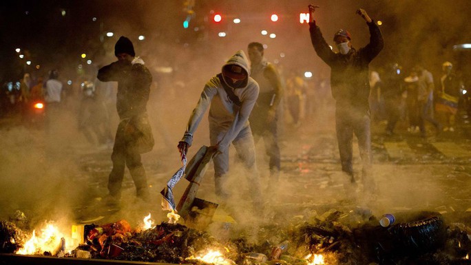 Người biểu tình đốt rác trên đường. Ảnh: AP