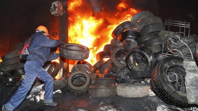 Người biểu tình đốt lốp xe gần rào chắn khu vực thủ đô. Ảnh: AP