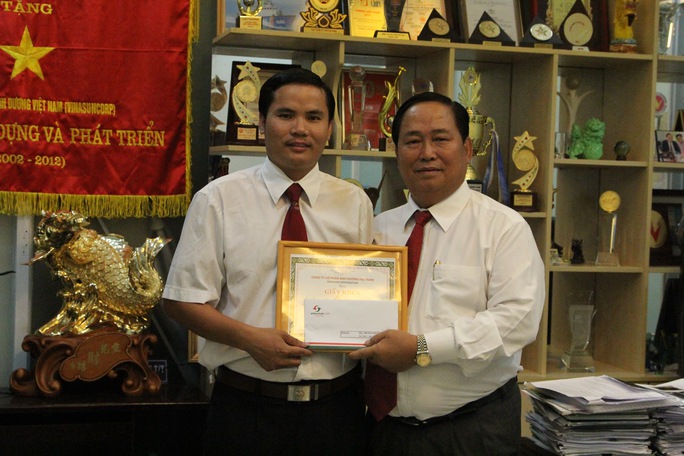 Leg: Ông Tạ Long Hỷ - Phó tổng giám đốc Vinasun (bìa phải), tặng giấy khen và tiền thưởng nóng cho tài xế Trương Khắc Hạnh