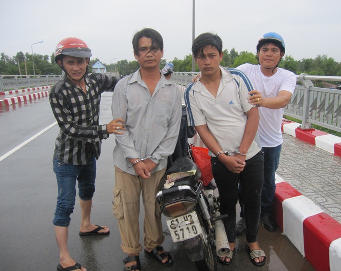 “Hiệp sĩ” Nguyễn Thanh Hải (bìa phải) và Thạch Đạt (bìa trái) đang khống chế 2 tên trộm xe vào chiều 29-8.