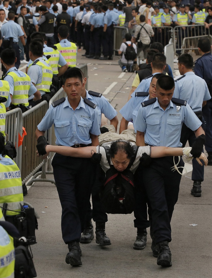 Cảnh sát bắt giữ một người biểu tình ngồi ở Hồng Kông hôm 2-7. Ảnh: AP