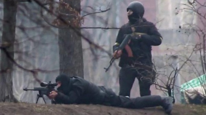 In cold blood: A riot policeman is seen standing next to a sniper in Kiev on February 20.