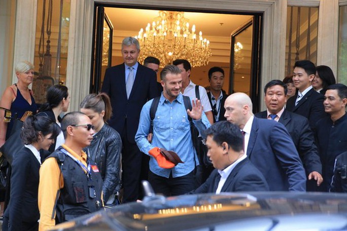 Beckham tươi cười chào các fan giữa sự bảo vệ nghiêm ngặt của các vệ sĩ. Ảnh: maskonline.vn