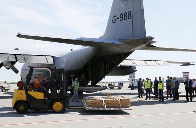 Quan tài chứa thi thể nạn nhân được đưa lên máy bay ở sân bay Kharkov để đến Hà Lan hôm 23-7. Ảnh: REUTERS