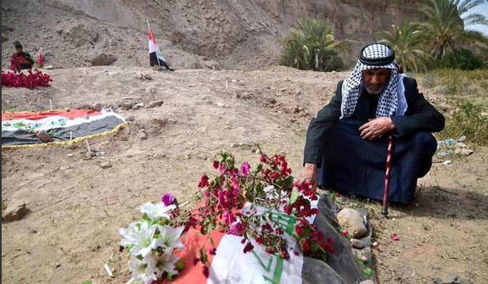 Cha một binh sĩ Iraq ngồi tại khu vực được cho là nơi con ông thiệt mạng tại TP Tikrit. Ảnh: Twitter