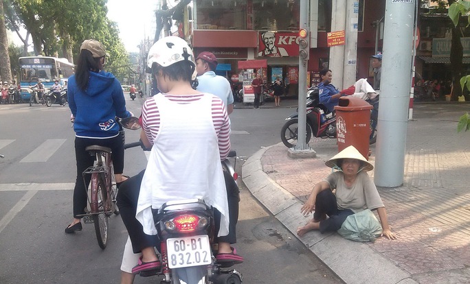 Ngay tại trung tâm thành phố, đoạn giữa Nguyễn Thị Minh Khai và Mạc Đỉnh Chi, người phụ nữ này thản nhiên ngồi xin tiền những người dừng xe chờ đèn đỏ