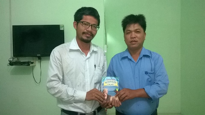 Anh Nguyễn Quang Thạch (bên trái) tặng sách cho người em họ làm việc tại xã Vĩnh Tân, huyện Tuy Phong, tỉnh Bình Thuận trong ngày thứ 105 trên đường đi bộ về TP HCM 
(Ảnh do nhân vật cung cấp)