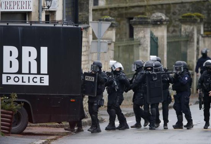 Cảnh sát tìm kiếm từng ngôi nhà trong làng Longpont, Đông Bắc Paris, hôm 8-1. Ảnh: Reuters