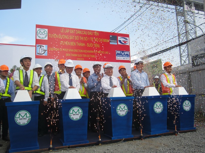 Thứ trưởng Bộ GTVT Nguyễn Ngọc Đông cùng lãnh đạo UBND TP HCM và tỉnh Bình Dương thực hiện nghi thức lắp đặt đốt dầm đầu tiên của tuyến metro số 1 sáng 4-6