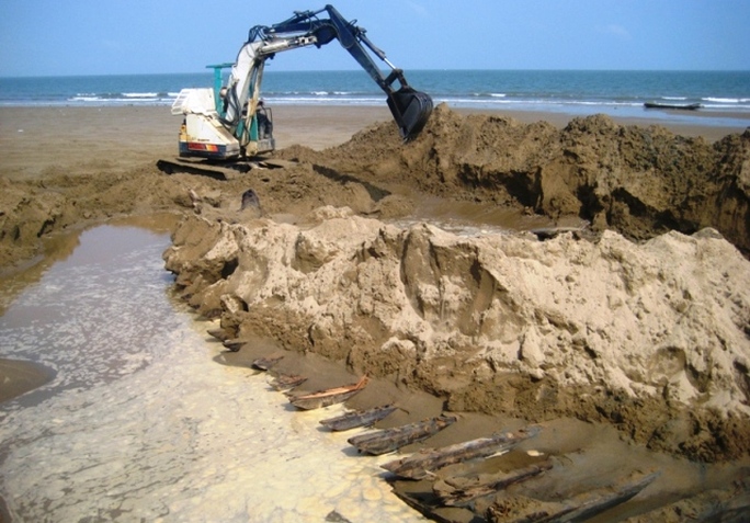 Xác con tàu gỗ vùi trong cát đang được cơ quan chức năng khai quật