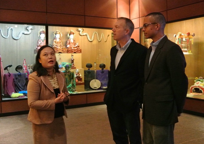 Hai ông nghe hướng dẫn viên bảo tàng giới thiệu về văn hoá truyền thống Việt Nam
