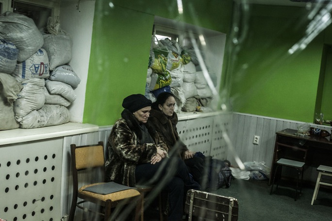 Ukrainian women sit in a shelter during a exchange of artillery fire between DNR forces and the Ukrainian Army in the Voroshilovsky area, center of Donetsk, ...