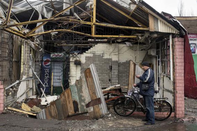 A man checks his mobile phone in front of his destroyed house in the town of Debaltseve, north-east from Donetsk, March 13, 2015. REUTERS-Marko Djurica