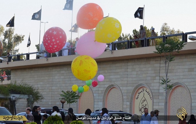 Party time: ISIS chilling black and white banners are seen fluttering in the wind while an array of brightly-coloured balloons are released into the air in celebration at the hotels reopening