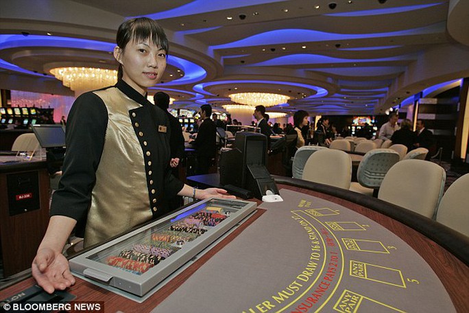 A croupier poses at the opening of the Sands Casino in Macau in 2005. The Chinese government has become concerned by the amount of money gambled away by its own officials on trips to the city