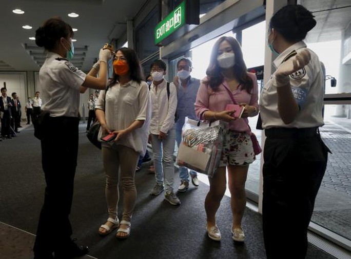 Du khách Hàn Quốc được kiểm tra thân nhiệt tại sân bay Hồng Kông. Ảnh: Reuters