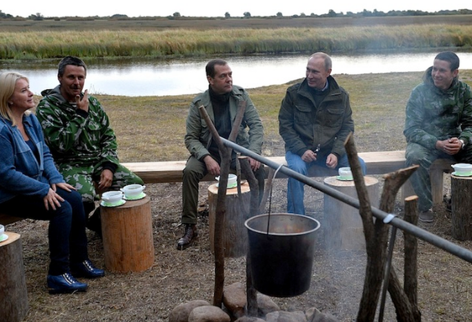Ông Putin và ông Medvedev mỉm cười khi ăn súp cá ngoài trời. Ảnh: ĐIỆN KREMLIN