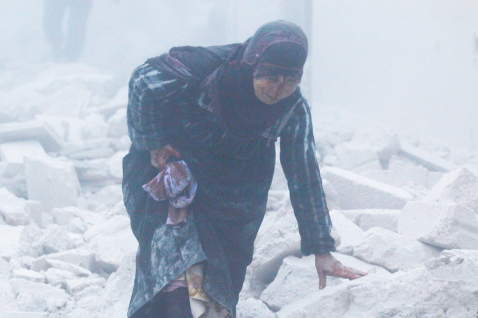 Một phụ nữ bị thương trong vụ không kích xuống khu vực do phe nổi dậy kiểm soát ở TP Aleppo hôm 7-12 Ảnh: Reuters