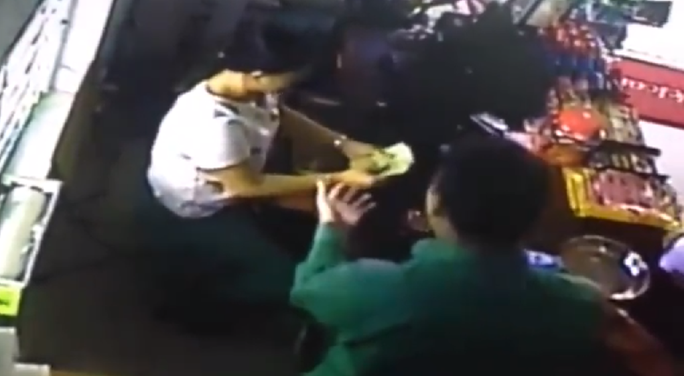  Chị H. lấy tiền đưa cho người đàn ông Ảnh cắt từ clip 