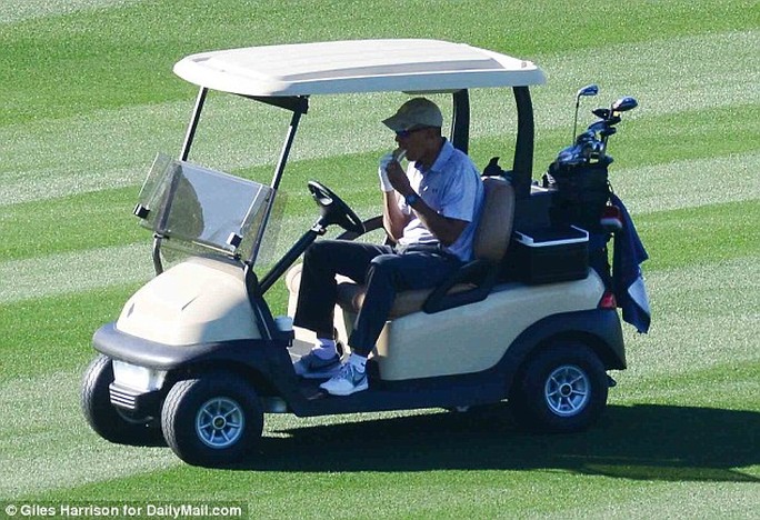 
Ông Obama tự lái xe và tranh thủ thưởng thức món bánh mì kẹp. Ảnh: Daily Mail
