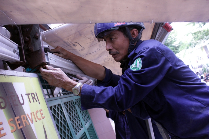 
Trên đường Nguyễn Bình Khiêm, một số trường hợp vi phạm cũng bị xử lý, tịch thu đồ đạc lấn chiếm. Trong ảnh: Một công nhân đang tháo dỡ mái che một quán nước.
