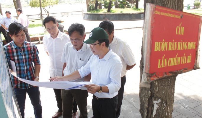 
Chủ tịch quận 1 xem xét bản vẽ của đề án xây dựng phố Hàng Rong tại công viên Bạch Đằng.
