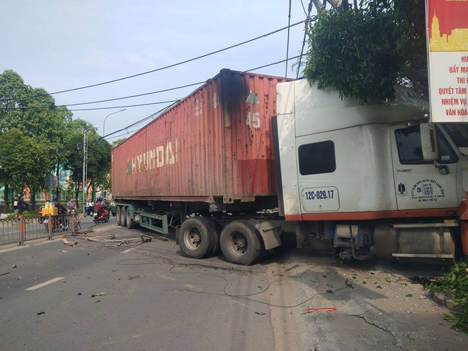 Kinh hoàng xe container san phẳng dải phân cách rồi lao vào cửa hàng ở TP HCM - Ảnh 1.