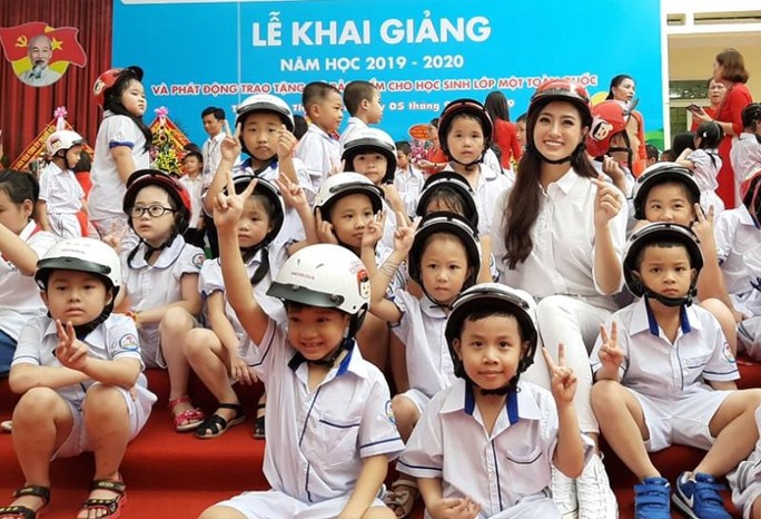 Hoa hậu Lương Thùy Linh trao mũ bảo hiểm cho học sinh trong ngày khai giảng - Ảnh 12.