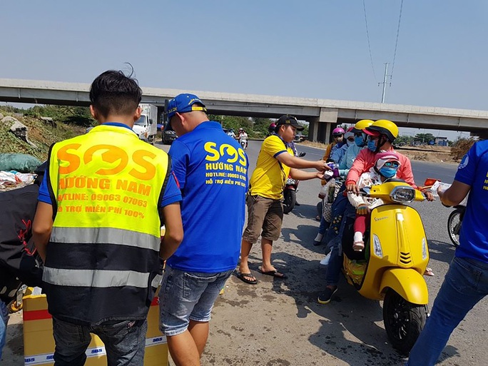 Người dân ra cửa ngõ TP HCM phát nước suối, vá xe miễn phí - Ảnh 1. Người dân ra cửa ngõ TP HCM phát nước suối, vá xe miễn phí - Ảnh 1.