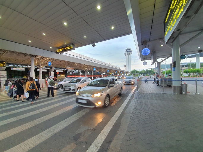 Vẫn có tài xế gỡ logo “xe hợp đồng” để vào sân bay Tân Sơn Nhất đón khách  - Ảnh 1.