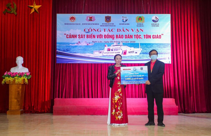 Báo Người Lao Động và Bộ Tư lệnh Cảnh sát biển trao tặng cờ Tổ quốc, quà cho người dân Nghệ An - Ảnh 1.