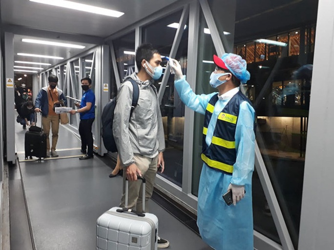 Từ vùng dịch nước ngoài về, hành khách vừa xuống máy bay liền được phun khử trùng toàn thân - Ảnh 1. Từ vùng dịch nước ngoài về, hành khách vừa xuống máy bay liền được phun khử trùng toàn thân - Ảnh 1.