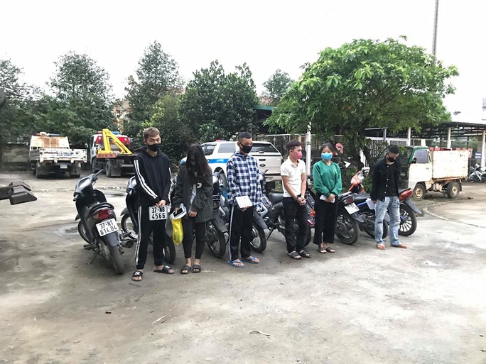 Bất chấp lệnh cấm, nhóm nam nữ thanh niên đi xe máy dàn hàng ngang, lạng lách - Ảnh 1.