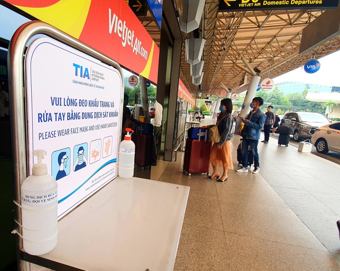 Sân bay Tân Sơn Nhất đông nghẹt ngày 25 Tết, nhiều khách trùm kín người để phòng dịch - Ảnh 6.