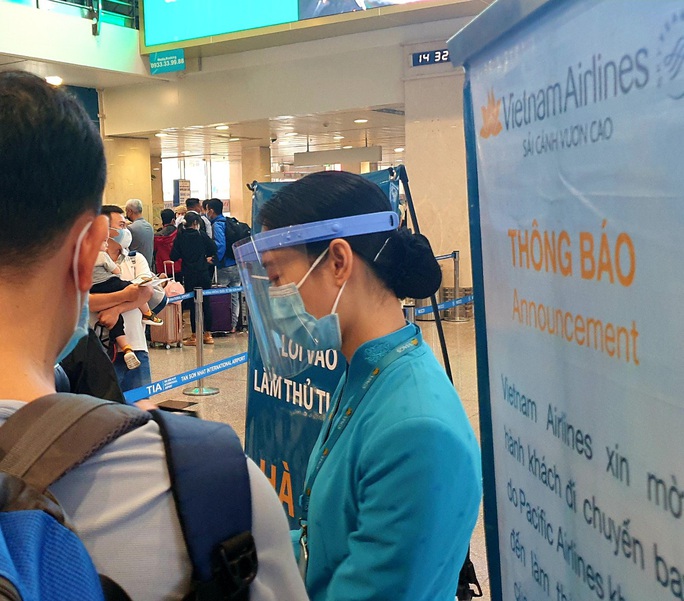 Sân bay Tân Sơn Nhất đông nghẹt ngày 25 Tết, nhiều khách trùm kín người để phòng dịch - Ảnh 3.