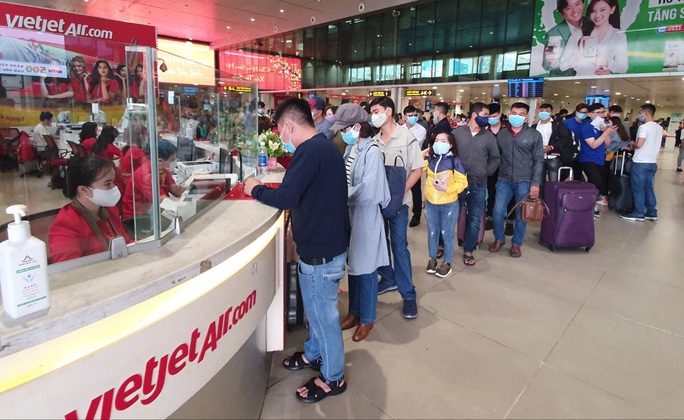 Sân bay Tân Sơn Nhất đông nghẹt ngày 25 Tết, nhiều khách trùm kín người để phòng dịch - Ảnh 11.