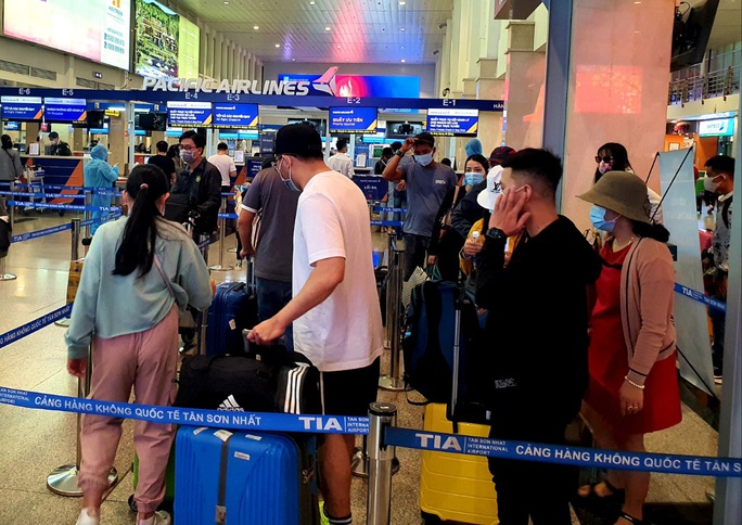 Sân bay Tân Sơn Nhất đông nghẹt ngày 25 Tết, nhiều khách trùm kín người để phòng dịch - Ảnh 10.