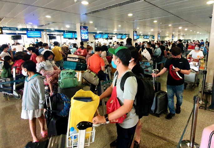 Sân bay Tân Sơn Nhất đông nghẹt ngày 25 Tết, nhiều khách trùm kín người để phòng dịch - Ảnh 14.