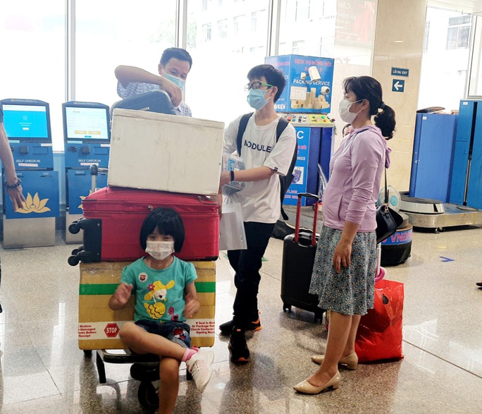 Sân bay Tân Sơn Nhất đông nghẹt ngày 25 Tết, nhiều khách trùm kín người để phòng dịch - Ảnh 12.
