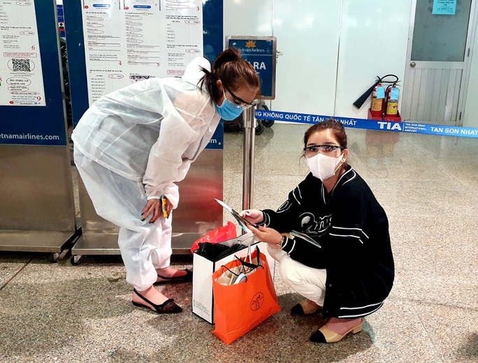 Sân bay Tân Sơn Nhất đông nghẹt ngày 25 Tết, nhiều khách trùm kín người để phòng dịch - Ảnh 5.