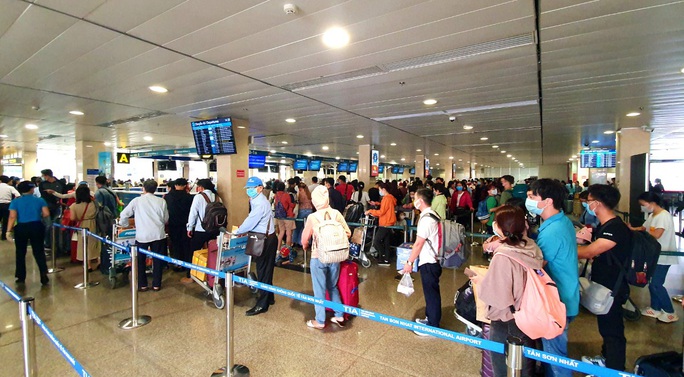 Sân bay Tân Sơn Nhất đông nghẹt ngày 25 Tết, nhiều khách trùm kín người để phòng dịch - Ảnh 13.