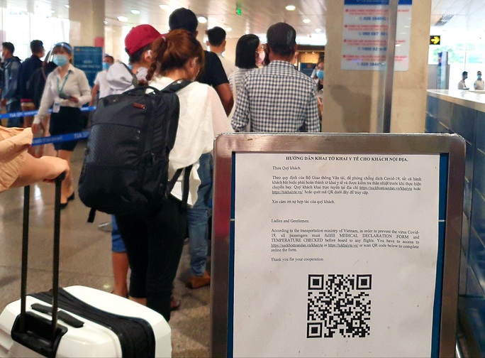 Sân bay Tân Sơn Nhất đông nghẹt ngày 25 Tết, nhiều khách trùm kín người để phòng dịch - Ảnh 8.