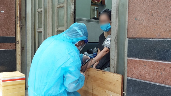 Nhân viên y tế tại Trạm Y tế phường 8, quận 11, TP HCM thăm khám cho F0 tại nhà.